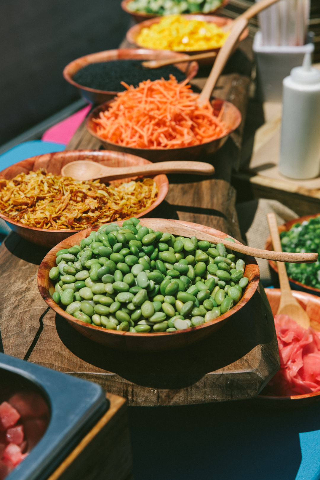 Poke bar of edamame, carrots and toppings in wooden bowls at the WAGcademy lunch