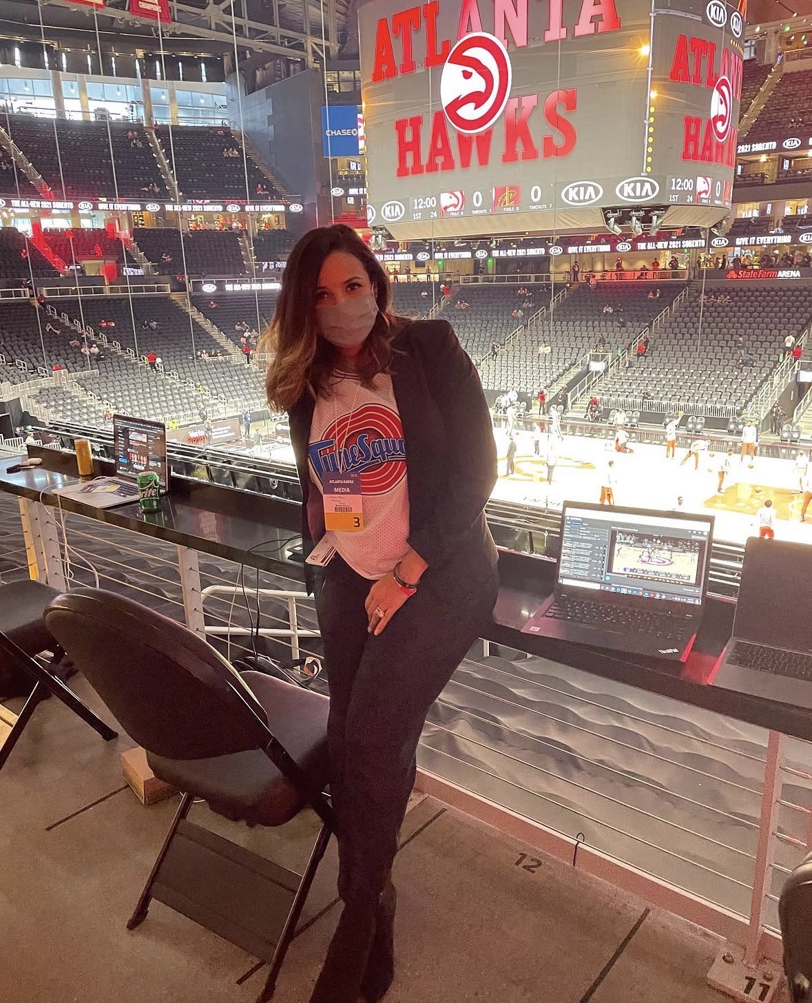 LeLe Martin on the media row at State Farm Arena before an Atlanta Hawks game, laptops and the Hawks jumbotron behind her