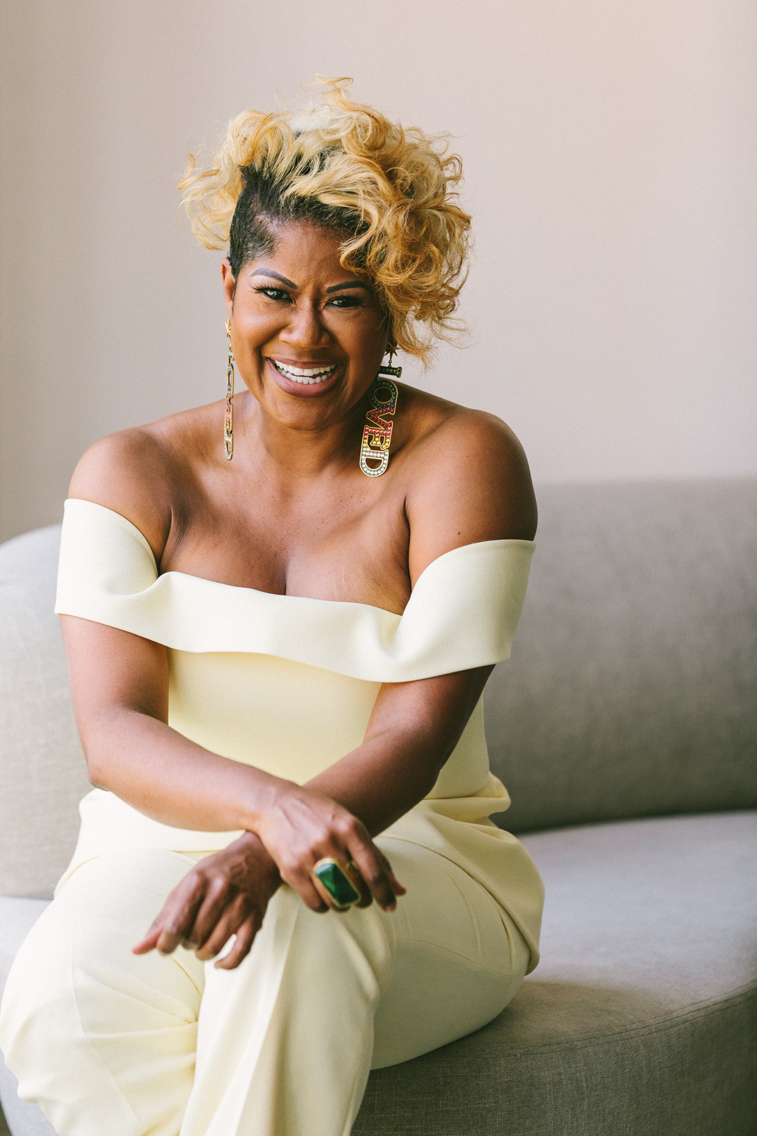 Founder in a cream off-the-shoulder suit seated and laughing between WAGcademy sessions