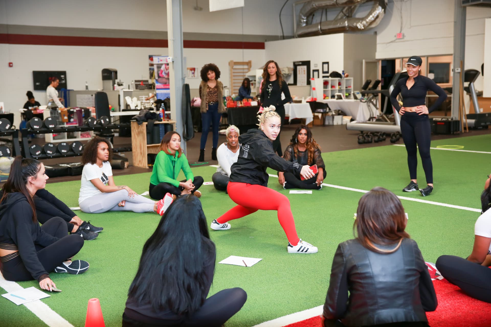 Trainer demonstrating a movement while members watch from the turf