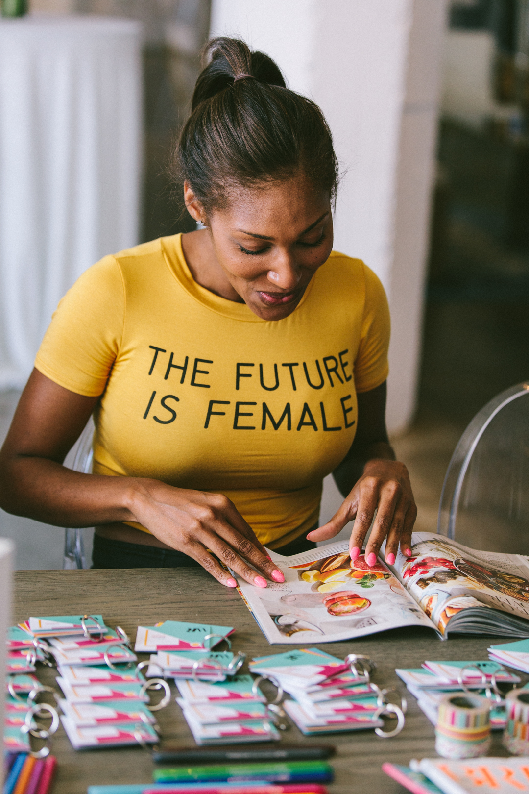 Founder in a The Future Is Female tee assembling swatch keychains at the prep table before doors opened