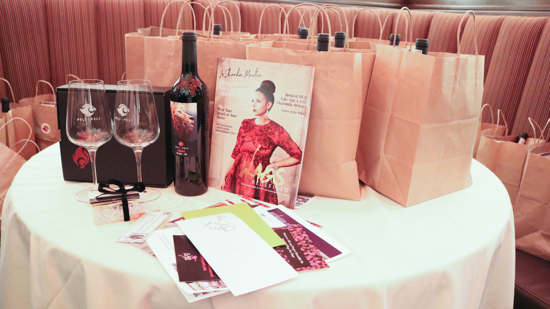 Gifting table with the WAGS Redefined magazine, Peli Peli wine and glassware beside guest bags