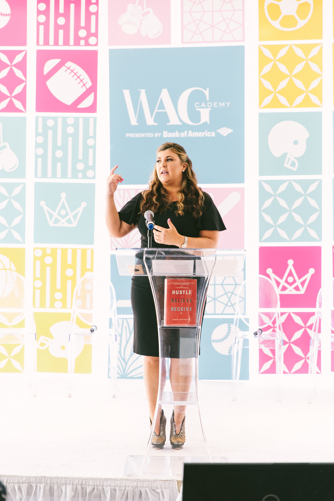 Speaker at the acrylic podium in front of the WAGcademy presented by Bank of America backdrop