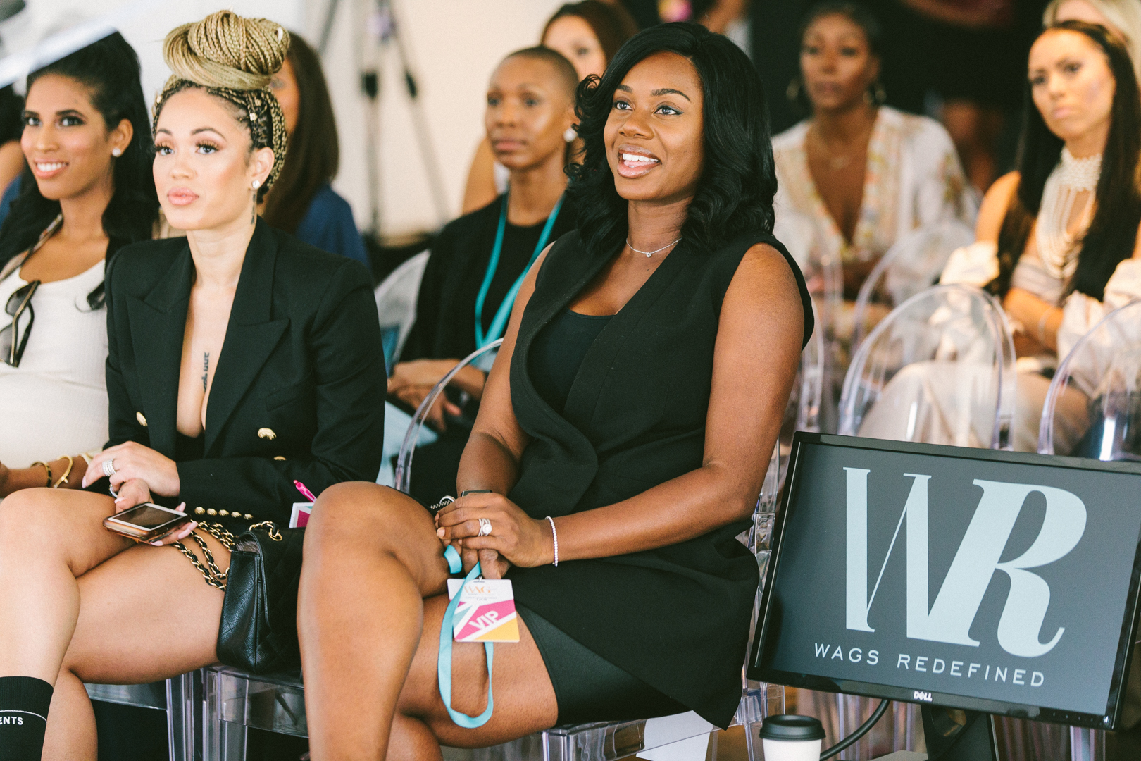 Attendees in the front row beside a WAGS Redefined screen