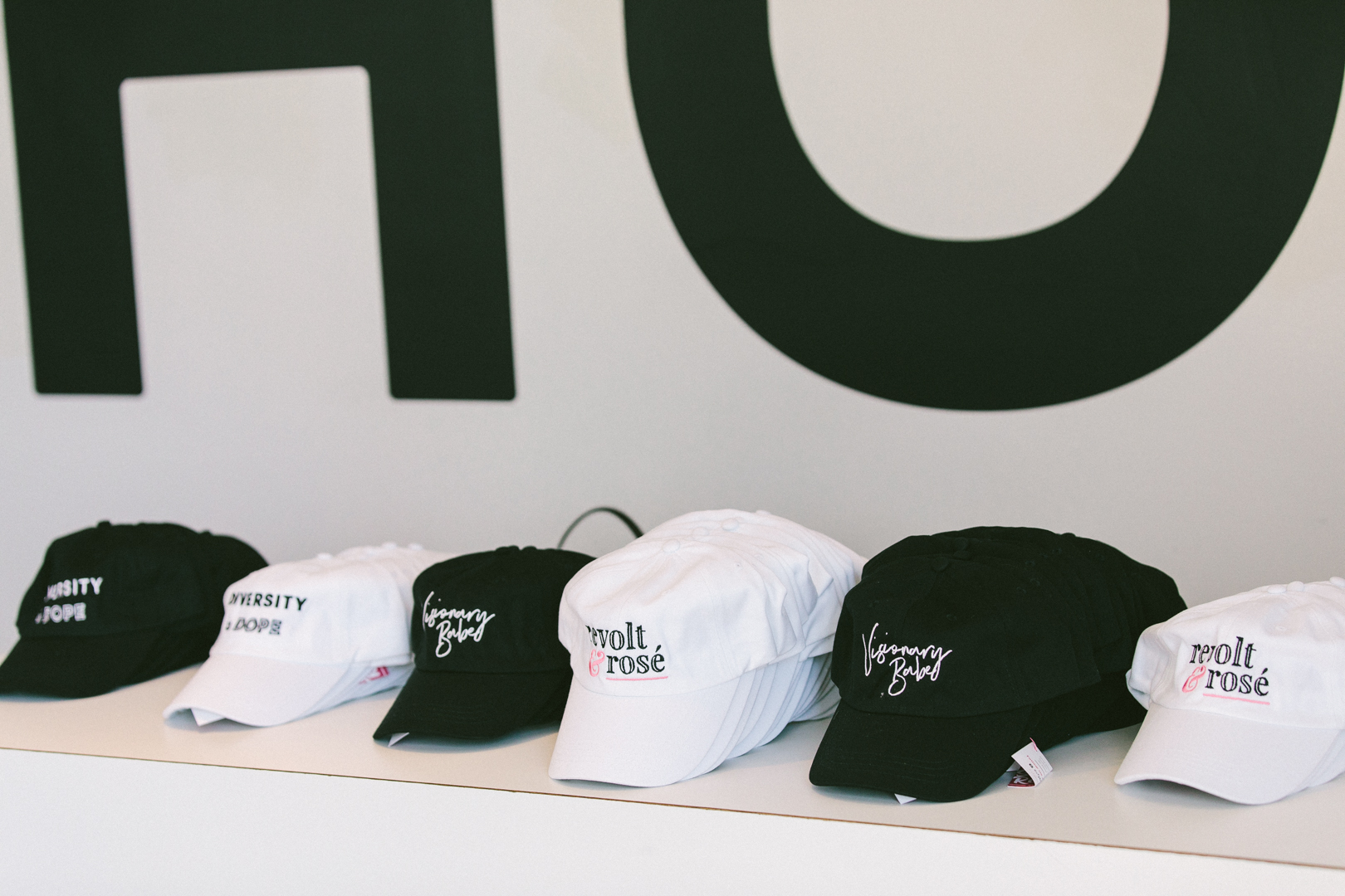 Varsity + Dope, Visionary Babe and Revolt & Rose caps from partner brands lined up on the retail shelf
