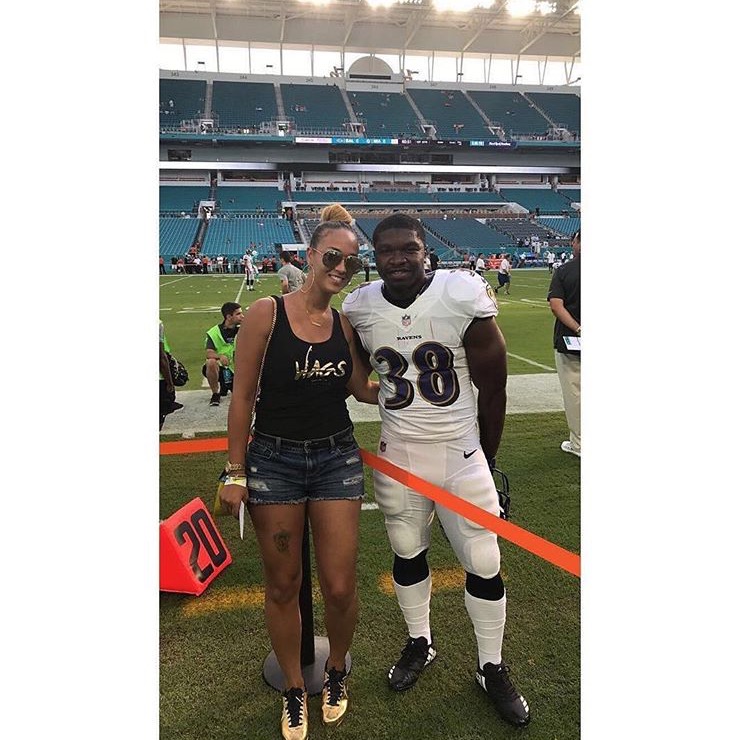 Member in a WAGS Redefined tank on an NFL sideline with a player in a Ravens jersey
