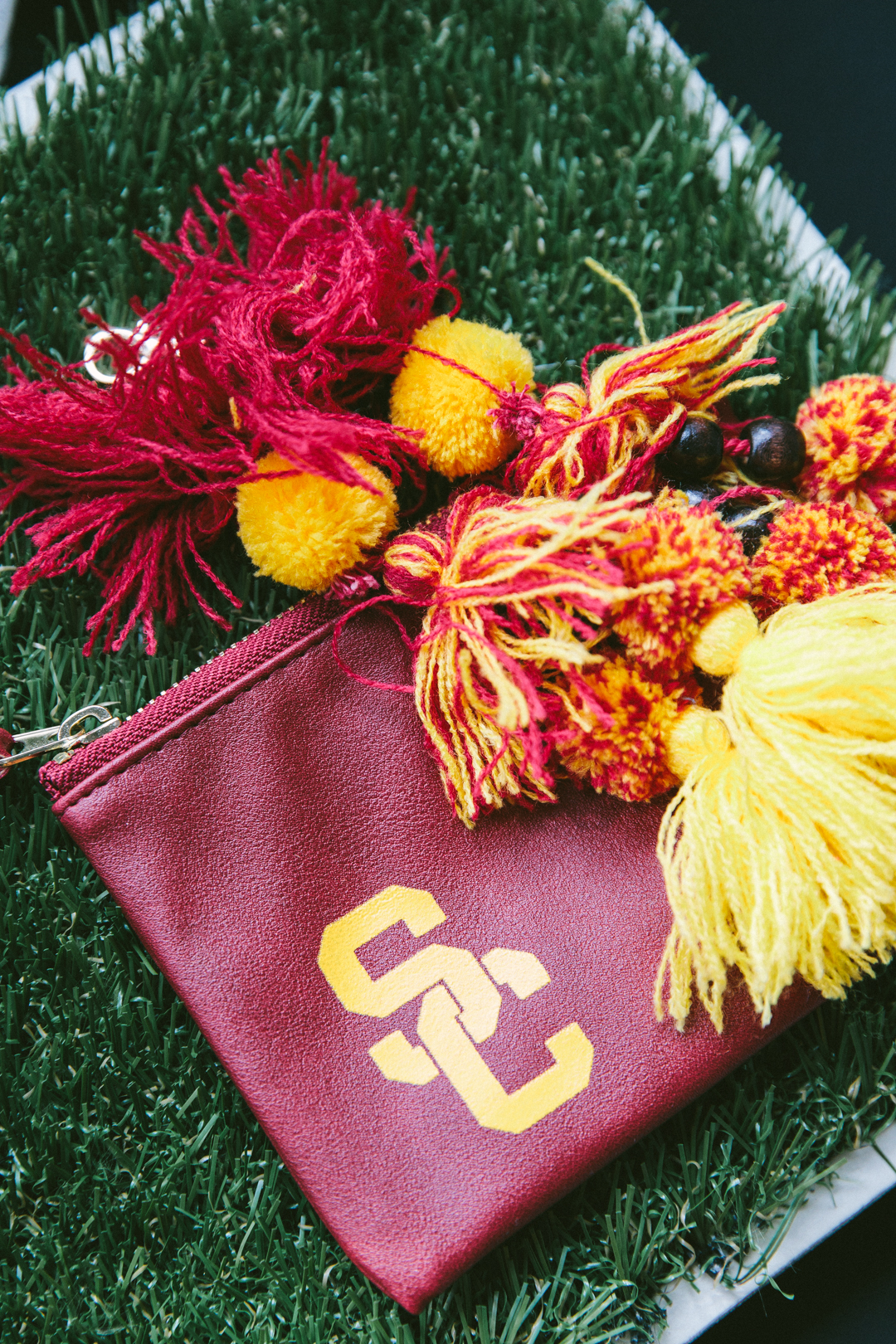 USC pouch and pom-pom keychains from the WAGcademy gifting suite on turf