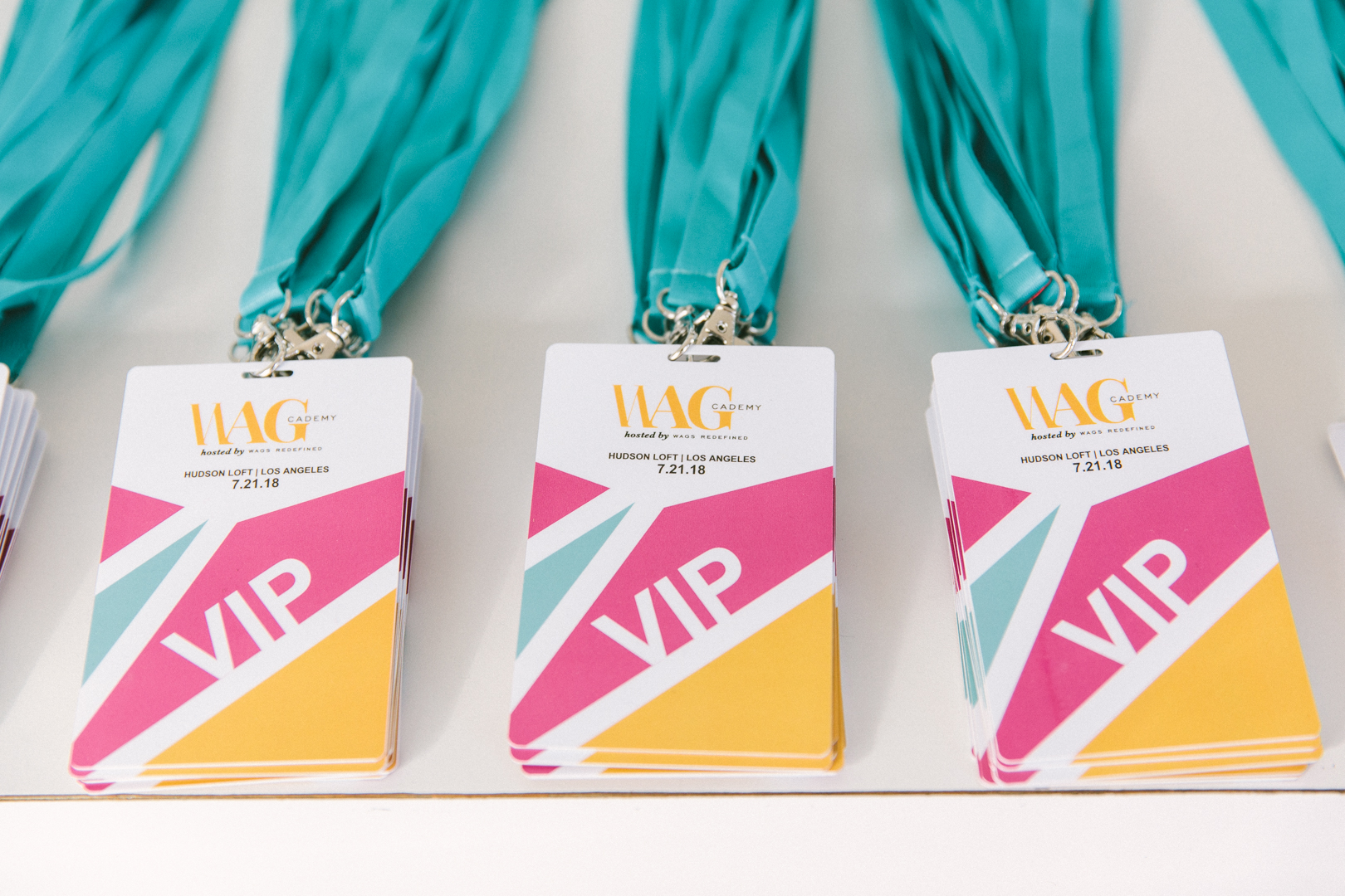 WAGcademy VIP badges on teal lanyards laid out on the check-in table
