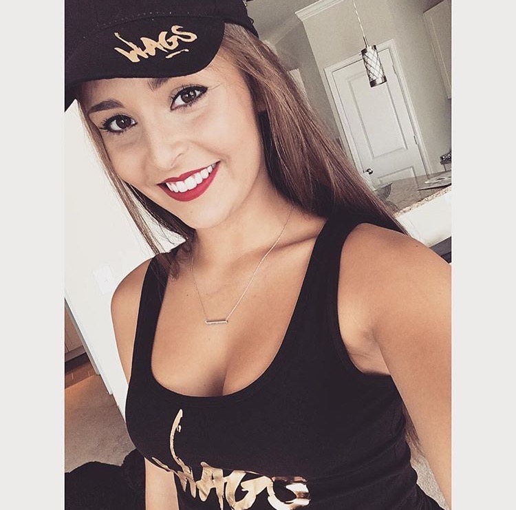 Member wearing a gold-foil WAGS Redefined cap and tank