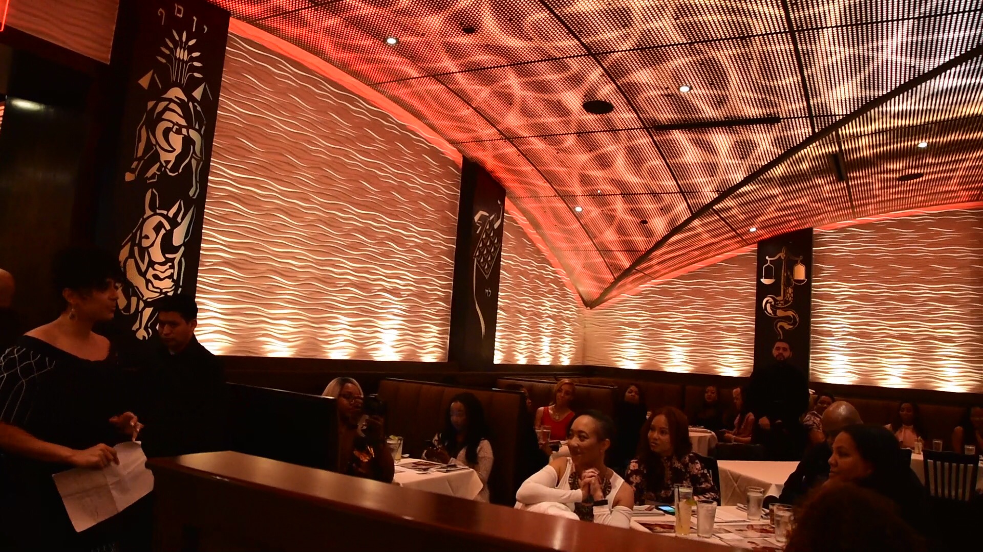 Private dinner room in Houston with guests seated beneath warm, patterned lighting