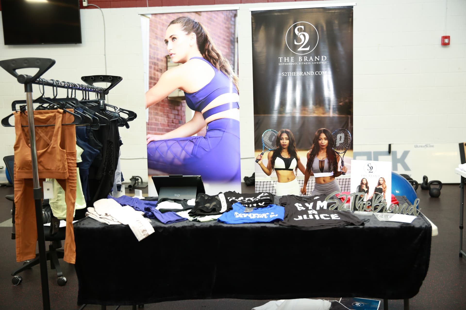 S2 The Brand vendor booth with banners, apparel rack and merchandise table