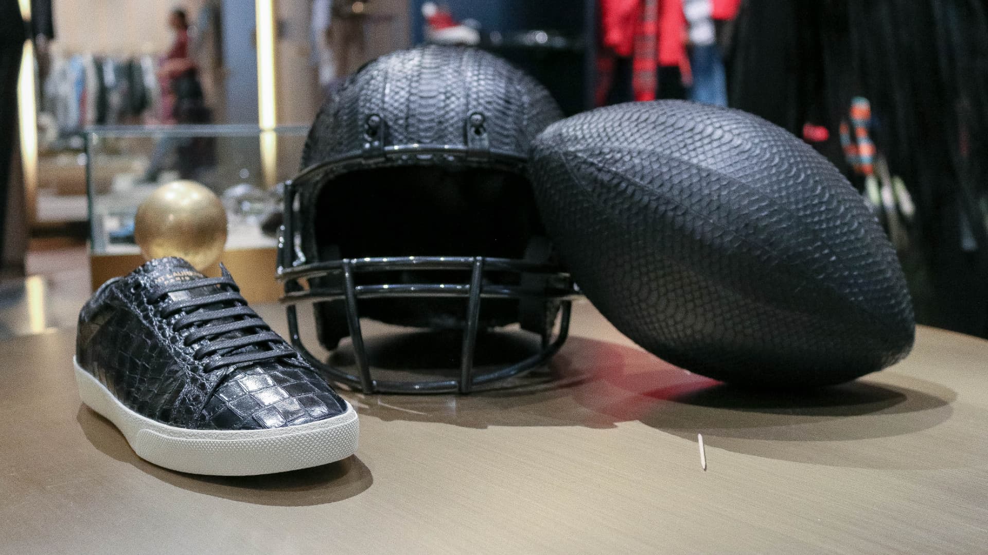 Python-textured football, helmet and sneaker styled on a display table