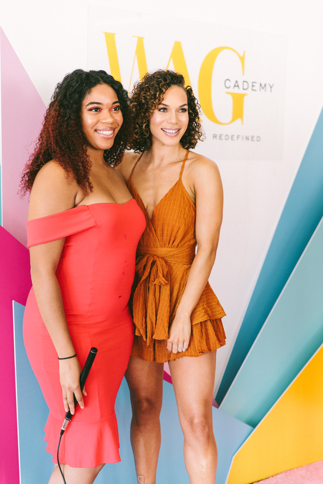 Host and a WAGcademy attendee on the step-and-repeat in front of the WAGcademy logo