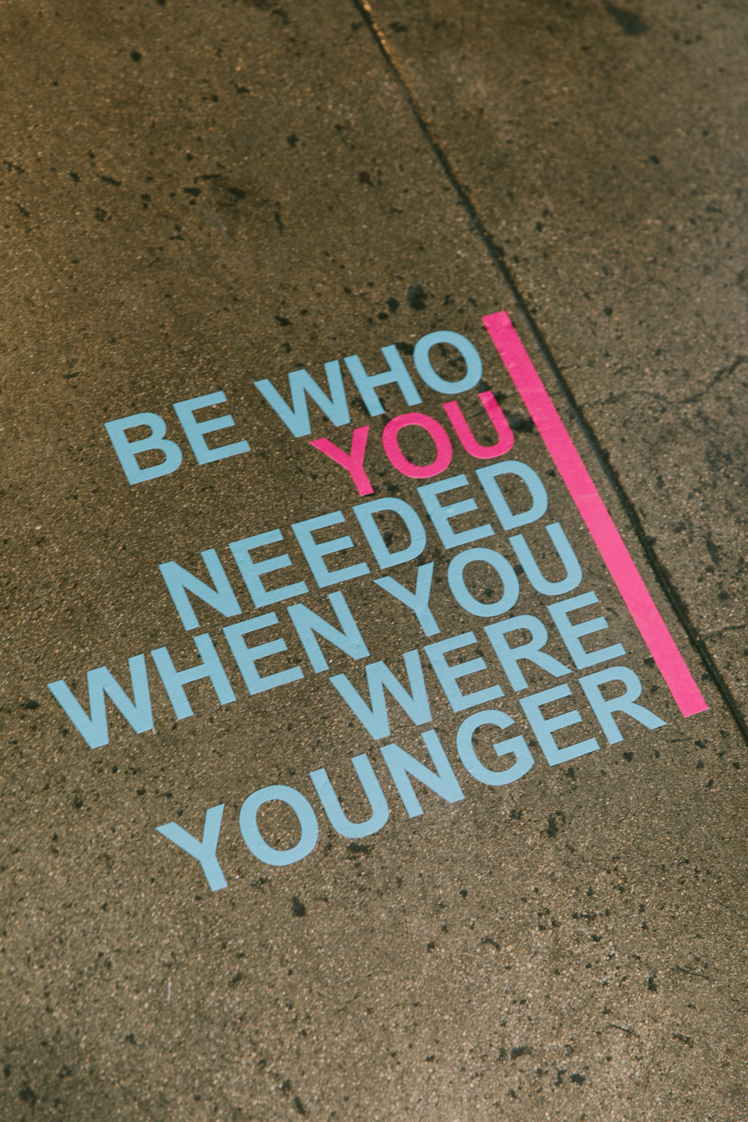 Floor decal reading BE WHO YOU NEEDED WHEN YOU WERE YOUNGER in WAGcademy blue and pink
